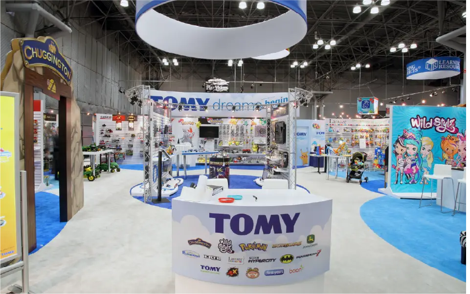 Overhead sign and curved display walls in Tomy 50 x 50 booth at Javits Center